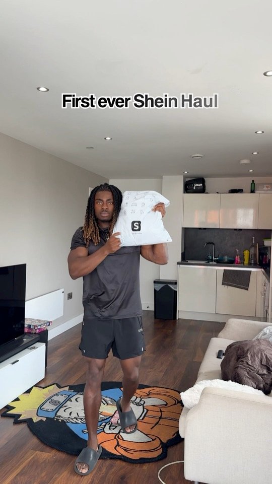 Still from a SHEIN reel: Kunle holding a SHEIN delivery package at home